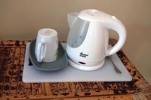 a tea kettle and a cup on a table at Wave House Gerupuk South Lombok in Praya
