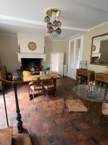 a living room with a dining table and a living room at Hôtel les Grands Chênes in Saint-Fargeau