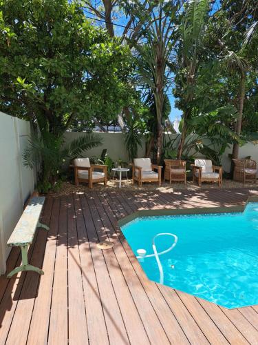 a swimming pool with a bench next to a wooden deck at THE BIG - Luxury Backpackers in Cape Town