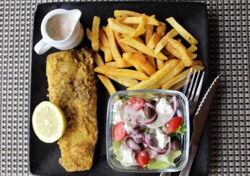a plate of food with a fish and french fries at Lions Rock Rapids - Lodge in Hazyview