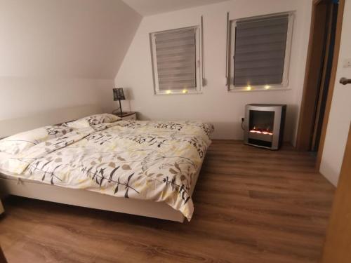 a bedroom with a bed and a fireplace at Planinska kuca NATURA in Vlasic