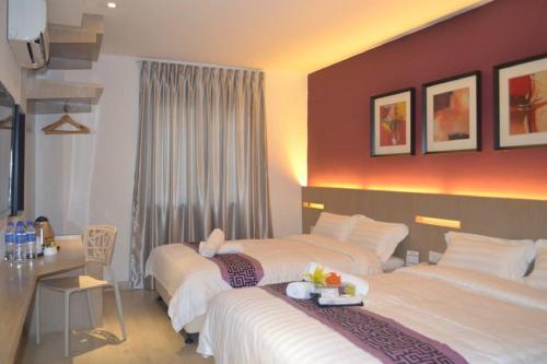 pokój hotelowy z 2 łóżkami i stołem w obiekcie Ashley Boutique Hotel w mieście Kota Damansara