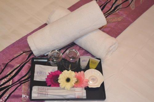 a tray with wine glasses and flowers on a bed at Ashley Boutique Hotel in Kota Damansara