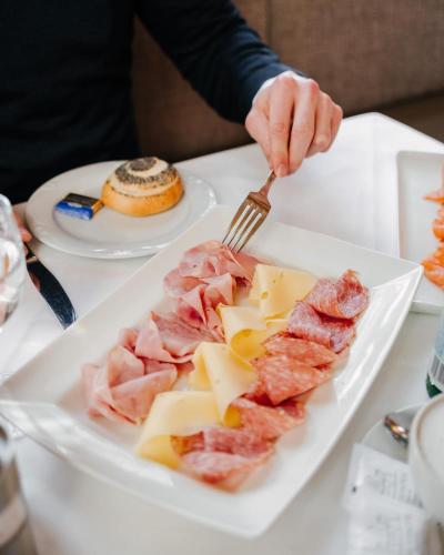 a person eating food on a plate with a fork at Schlosshotel Grünwald in Grünwald