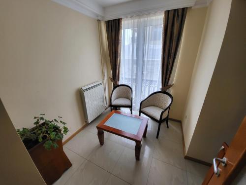 a room with two chairs and a table and a window at Sunny Hill Apartments & Aqua Park in Vrnjačka Banja