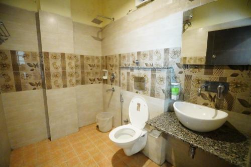 a bathroom with a toilet and a sink at Hotel Gaurab Near Railway Station in Dehradun