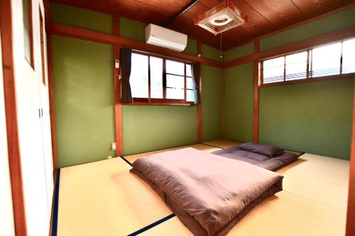 a room with a bed in a room with green walls at ゲストハウス　鍼灸院　boshcetto in Yoshino