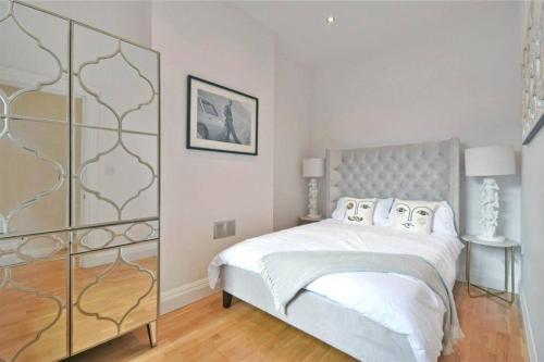 Dormitorio blanco con cama con sábanas y almohadas blancas en Private 2 Bed Apartment / HUGE OUTDOOR TERRACE, en Londres