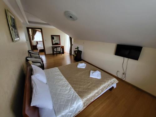a bedroom with a bed with two white towels on it at Sunny Hill Apartments & Aqua Park in Vrnjačka Banja