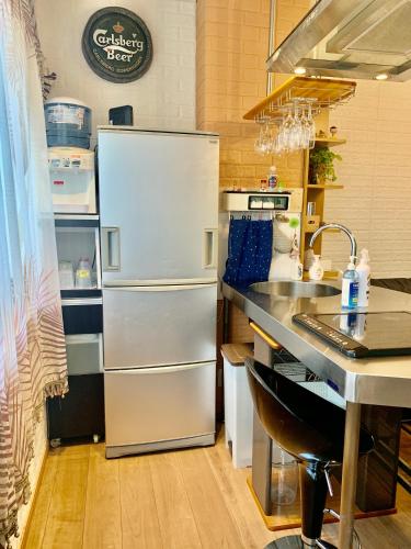 a kitchen with a refrigerator and a sink at YokohamaKannai HouseBar in Yokohama