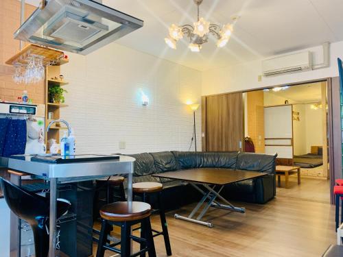 een woonkamer met een bank en een tafel bij YokohamaKannai HouseBar in Yokohama