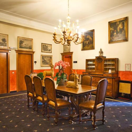 a dining room with a table and chairs and a chandelier at Schlosshotel Grünwald in Grünwald