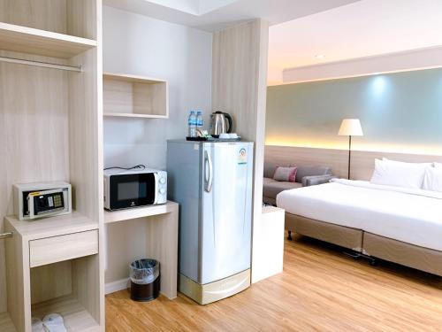 a hotel room with a bed and a refrigerator at Miloft Sathorn Hotel - SHA Plus Certified in Bangkok