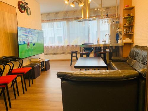 a living room with a couch and a tv and a table at YokohamaKannai HouseBar in Yokohama