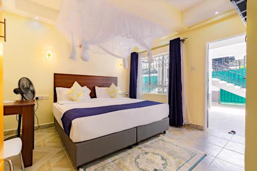 1 dormitorio con cama, escritorio y ventana en Marrkson Suites, en Nairobi