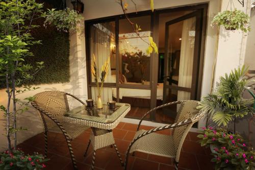 a patio with two chairs and a glass table at Golden Sail Hotel & Spa in Hanoi