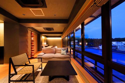 a living room with a couch and a large window at Waqoo Naritasanmonzen in Narita