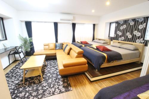 um quarto com uma cama e um sofá em Condominium Felicita Naha em Naha