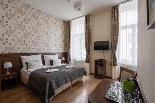 a hotel room with a bed and a tv at Elit Boutique Rooms- Best Location by BQA in Budapest