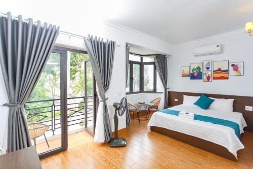 Un dormitorio con una cama y un balcón. en Blue Eyes Hotel, en Văn Lâm