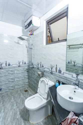 a bathroom with a white toilet and a sink at Blue Eyes Hotel in Văn Lâm