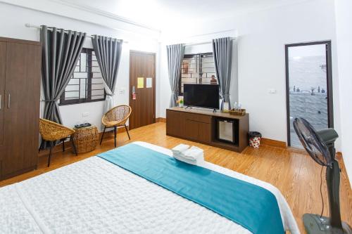 a bedroom with a large bed and a television at Blue Eyes Hotel in Văn Lâm