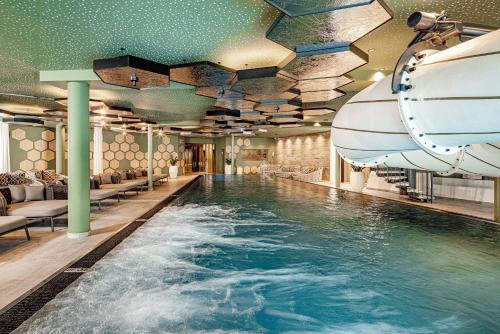 einen Pool in einem Hotel mit Rutsche in der Unterkunft Alpine Luxury SPA Resort Schwarzenstein in Luttach