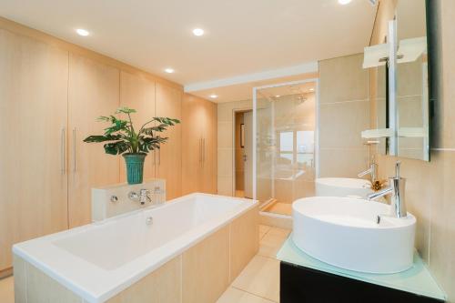 ein Badezimmer mit einer großen weißen Badewanne und einem Waschbecken in der Unterkunft Ocean View 505 Self Catering Accommodation Strand Western Cape South Africa in Strand