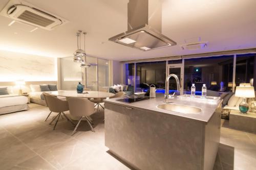 eine Küche und ein Wohnzimmer mit einem Waschbecken und einem Sofa in der Unterkunft Ronsard Resort IRABU in Miyako-jima