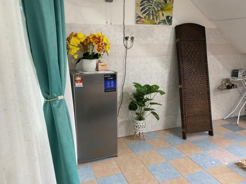 a room with a refrigerator and flowers on the wall at Heaven republic Studio in Kangar