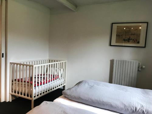 a bedroom with a crib and a radiator at Tiklo Bed and Breakfast in Arnborg