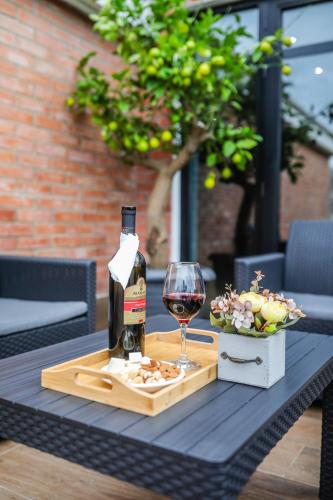 a bottle of wine and a glass on a table at Hotel InnDigo in Kutaisi in Kutaisi