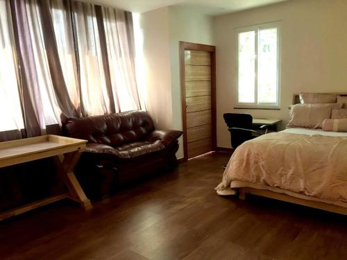 a bedroom with a bed and a couch and a chair at Mariya Condo hotel in Bodh Gaya