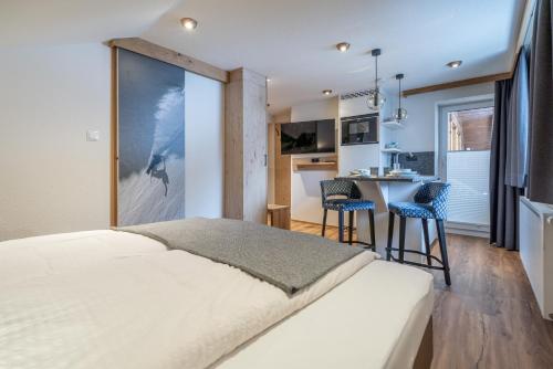 a bedroom with a large bed and a kitchen at Garni Ötztal ROOMS & APARTS in Sölden