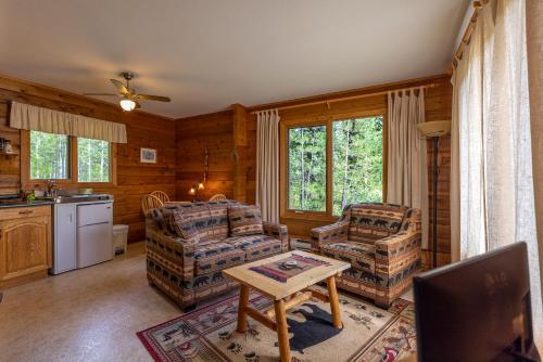 a living room with two chairs and a table at Mica Mountain Lodge & Log Cabins in Tete Jaune Cache
