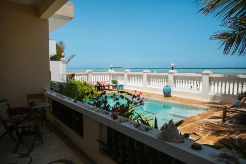 a balcony with a swimming pool and the ocean at Mambo Paradise in Matemwe