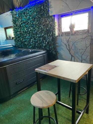 una mesa y un taburete frente a una cocina en Casawellness nuit insolite avec jacuzzi en Floreffe