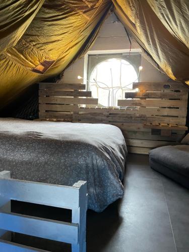 - une chambre dans une tente avec un lit et une fenêtre dans l'établissement Casawellness nuit insolite avec jacuzzi, à Floreffe