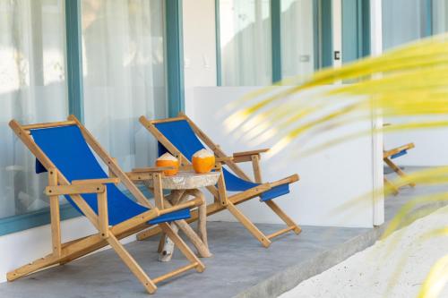 two chairs and a table with oranges on it at Manta Reserve in Maalhos