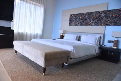 a bedroom with a large bed and a large window at Regenta Place Green Leaf Mahabaleshwar in Mahabaleshwar