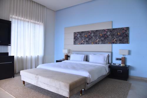 a bedroom with a large white bed and a large window at Regenta Place Green Leaf Mahabaleshwar in Mahabaleshwar