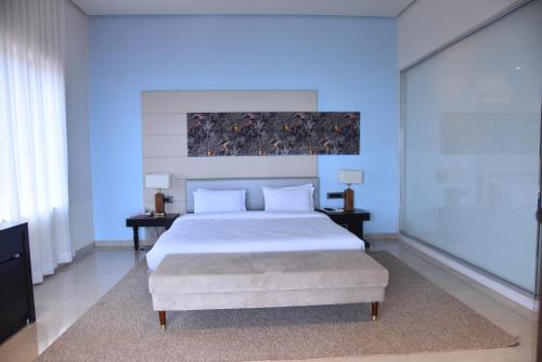 - une chambre avec un grand lit blanc et 2 tables dans l'établissement Regenta Place Green Leaf Mahabaleshwar, à Mahabaleshwar