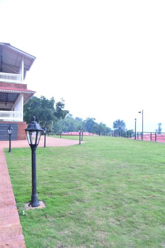 a street light in a grassy field next to a building at Regenta Place Green Leaf Mahabaleshwar in Mahabaleshwar