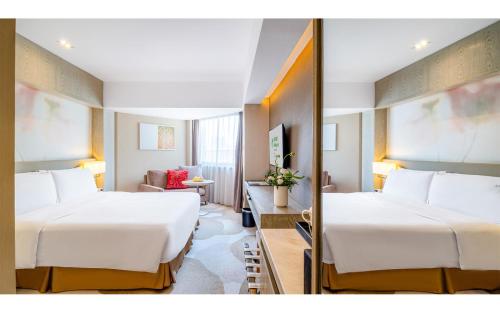 a hotel room with two beds and a mirror at Holiday Inn Kunming City Centre, an IHG Hotel in Kunming