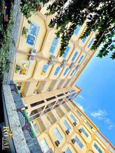 un edificio amarillo con ventanas laterales en Royal Village Hotel, en Dar es Salaam