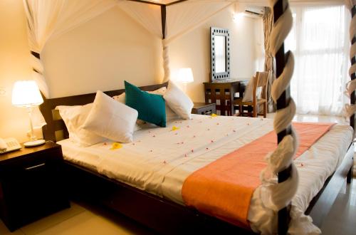 a bedroom with a large bed with shoes on it at Hotel Safari Gate in Bujumbura