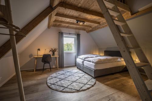 een slaapkamer op zolder met een bed en een bureau bij Vakantiehuis in een prachtige bosrijke omgeving in Twente! in Bornerbroek