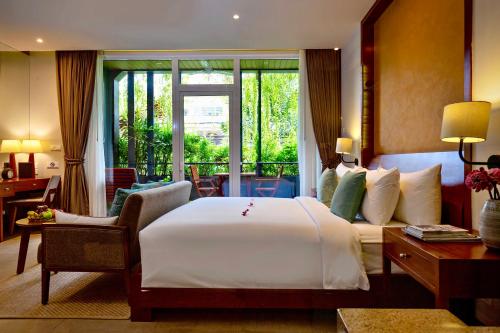 a hotel room with a large bed and a window at Indra Hotel in Phnom Penh
