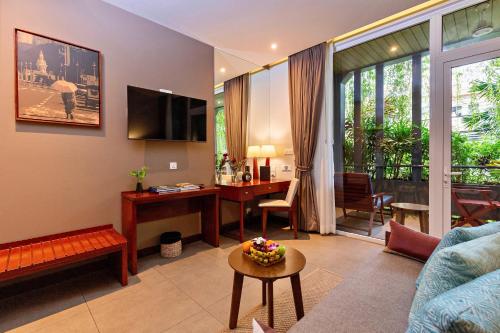 a living room with a couch and a table and a desk at Indra Hotel in Phnom Penh