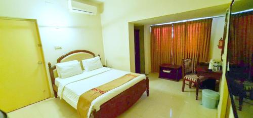 a hotel room with a bed and a window at Hotel Ornate in Dhaka